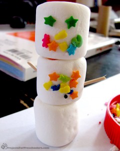 Add candy sprinkles and shapes to decorate marshmallow snowmen