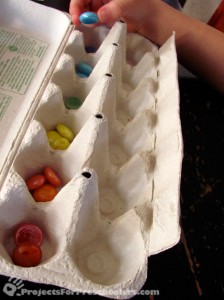 sorting mosaic gems by color in an egg carton