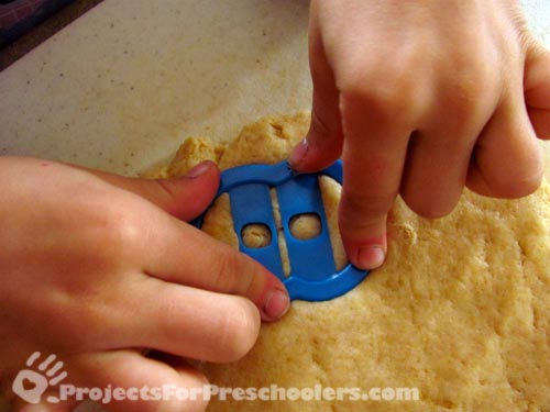 use alphabet cookie cutters to cut out doughnut shapes