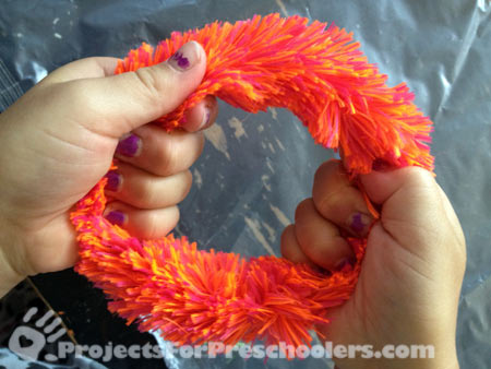 make a circle with a fuzzy pipe cleaner