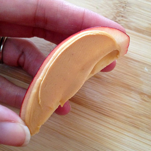 Put peanut butter on one edge of apple